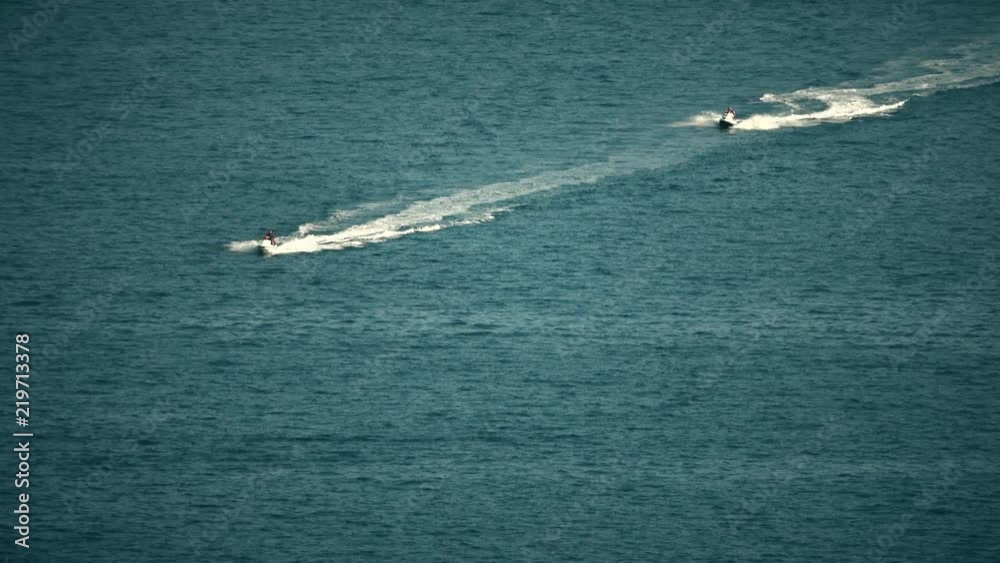 Two jet ski riders at sea. Telephoto lens shot Two jet ski riders at sea. Telephoto lens shot