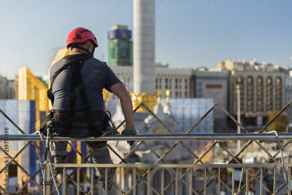 window washer climber in a break sitting on railing window washer climber in a break sitting on railing