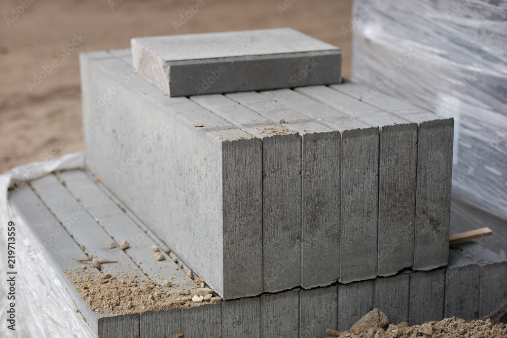 Road construction materials stacked on a pallet. Concrete curb for reinforcing the road shoulder.