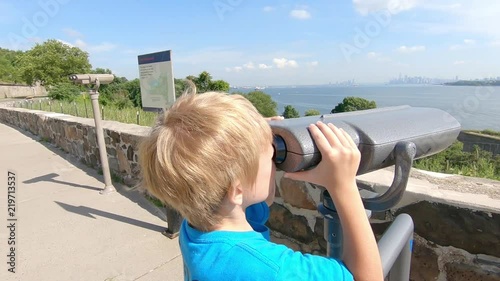 Boy looking at New York city trough  binoculars