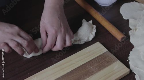 manos de mujer armando empanada rellena con carne photo