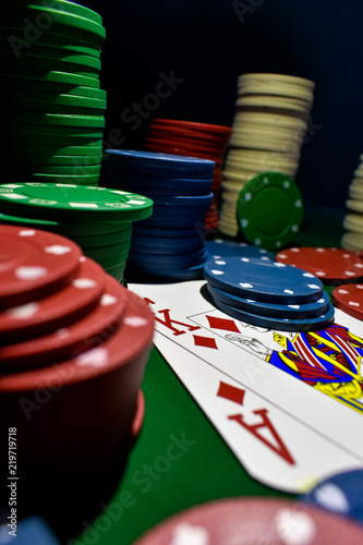 Poker Chips and playing cards on a green felt poker table
