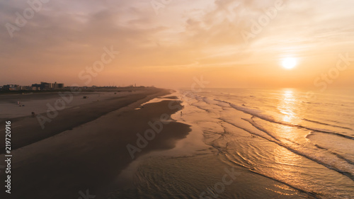 Beach Sunrise over Ocean and waves with cloudy purple yellow orange sky Aerial at New Jersey Shore