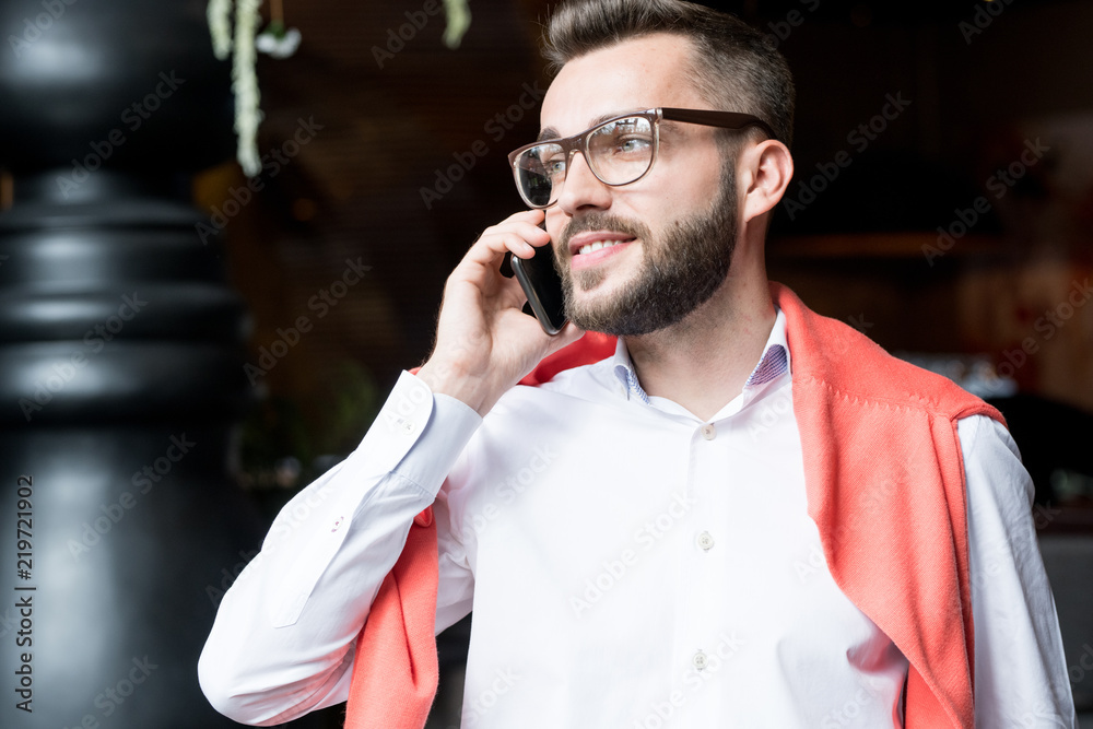 Φωτογραφία Waist up portrait of handsome young businessman speaking by phone and smiling lo