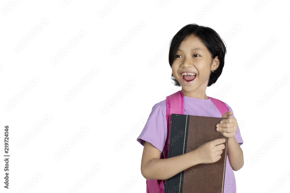 Happy schoolgirl carrying a book on studio Happy schoolgirl carrying a book on studio