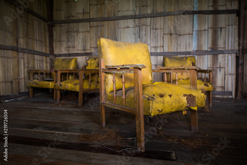obsolete old yellow leather chair in abondon house