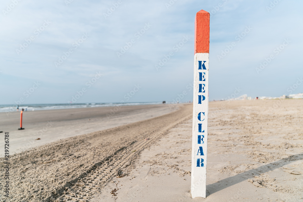 Keep Clear sign post on New Jersey Beach with Blue Sky in Background