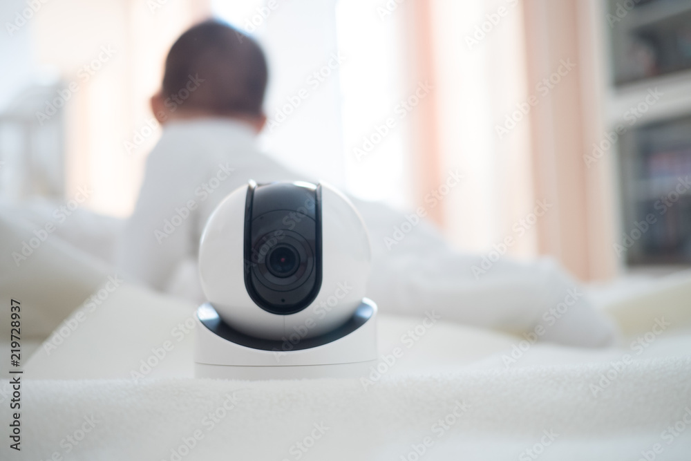 Fototapeta premium Baby monitor camera with blurred baby background for text space. concept of baby safty