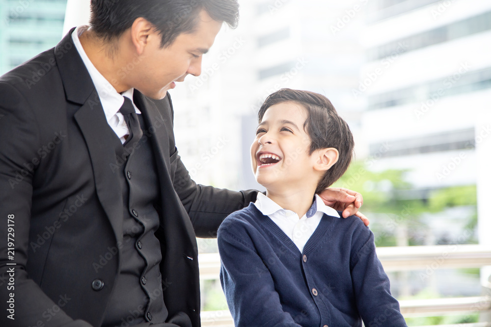 Portrait of Boy looking to father with attractive smile. Business man talking with his son with happy emotion. Portrait of Boy looking to father with attractive smile. Business man talking with his son with happy emotion.