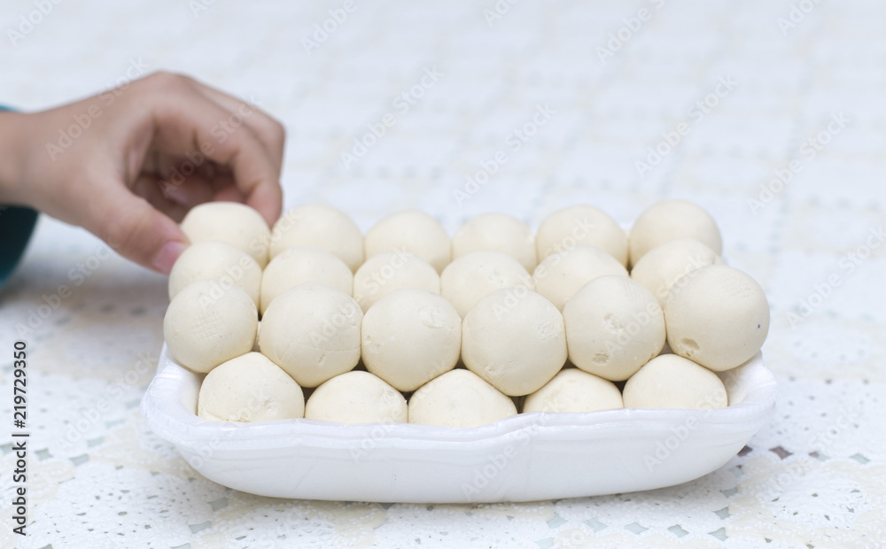 on the background of the Kazakh national kurta or round solid milk and a child's hand on the background of the Kazakh national kurta or round solid milk and a child's hand