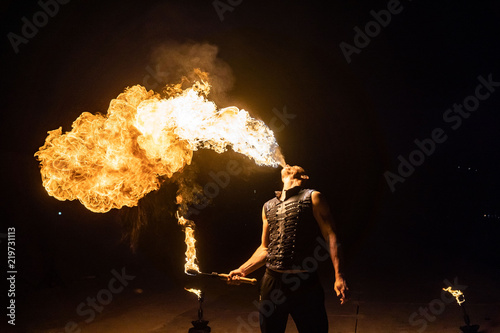 Fire show artist breathe fire in the dark photo