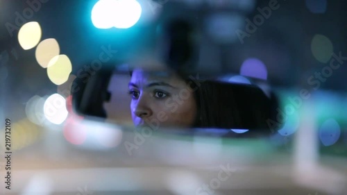 Woman driving at night seen through rear-view mirror2 photo