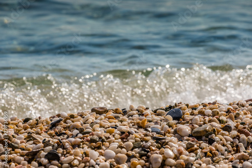Waves of the blue sea crashing onto a pebble beach in Maronia, Rodopi, Greece