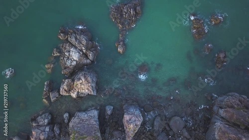 Aerial View of the Blue Wild Laguna Beach coastline bay with the rocks and cliffs. Flying above the ocean landscape and seascape. Drone view from top to the seashore and mountain. Waves coming slowly