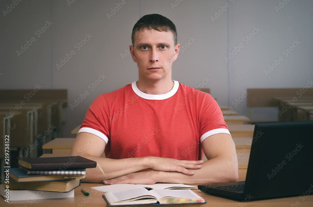 Serious student boy writing a lecture or exam work to the workbook. Serious student boy writing a lecture or exam work to the workbook.