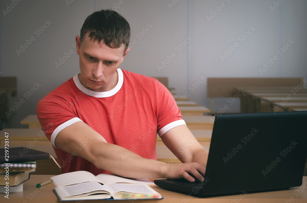 Serious student boy working on a laptop computer and prepare for exam. Serious student boy working on a laptop computer and prepare for exam.