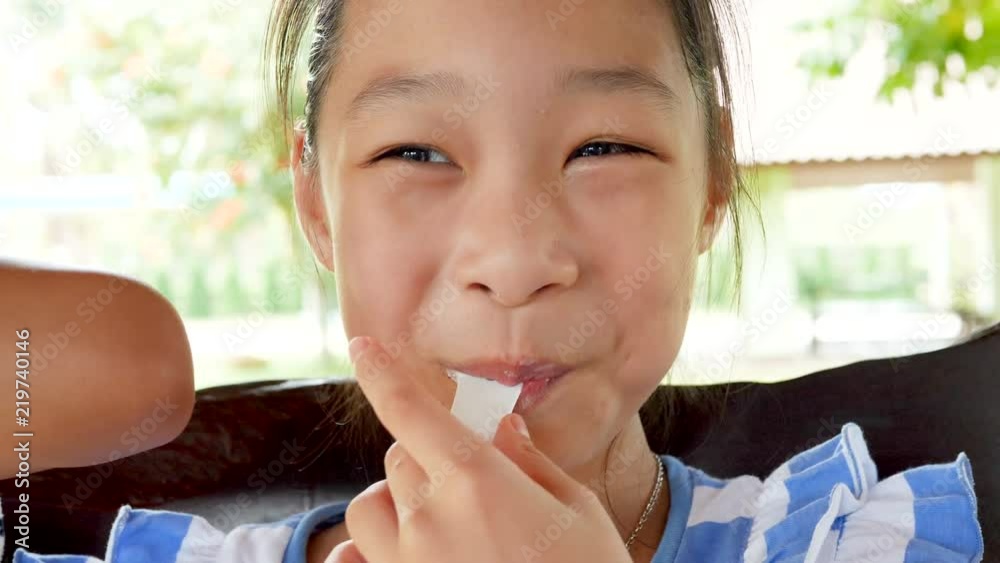 Asian kid sitting at cafe and eating ice-cream Asian kid sitting at cafe and eating ice-cream