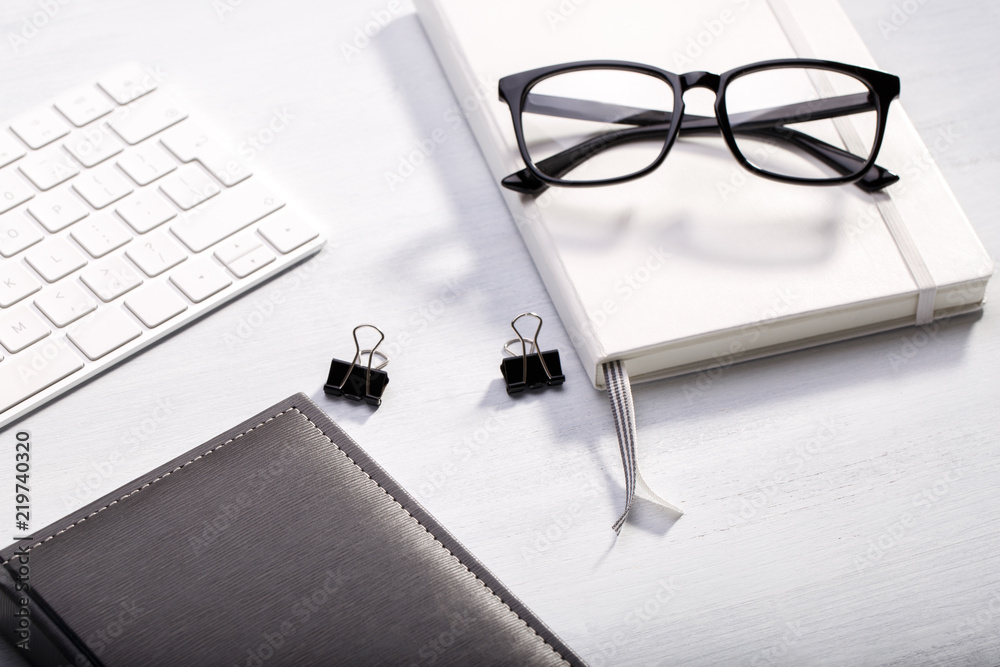Diary keyboard and glasses on modern desk, business or education concept, natural light Diary keyboard and glasses on modern desk, business or education concept, natural light