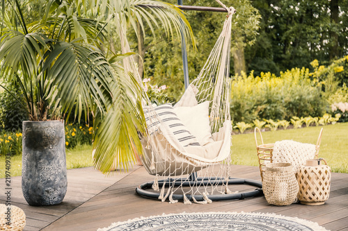Obraz na płótnie Summer in the green garden with a hammock and a palm tree on a terrace