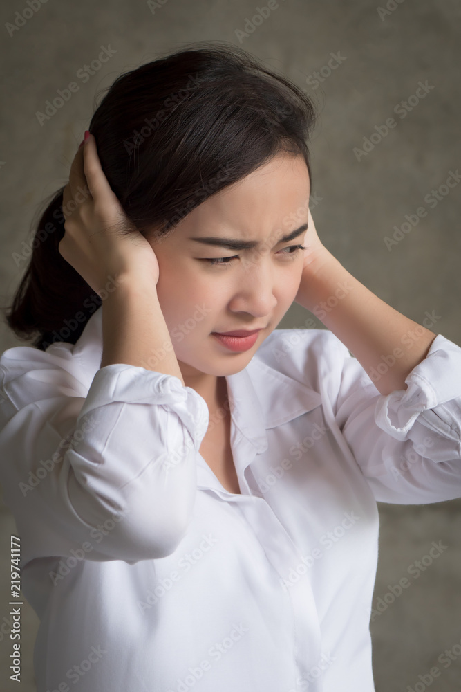 stressed woman covering, closing her ear not to hear bad news; portrait of sad, unhappy asian woman covering her both ears, concept of problem, trouble, frustration; asian young adult woman model stressed woman covering, closing her ear not to hear bad news; portrait of sad, unhappy asian woman covering her both ears, concept of problem, trouble, frustration; asian young adult woman model