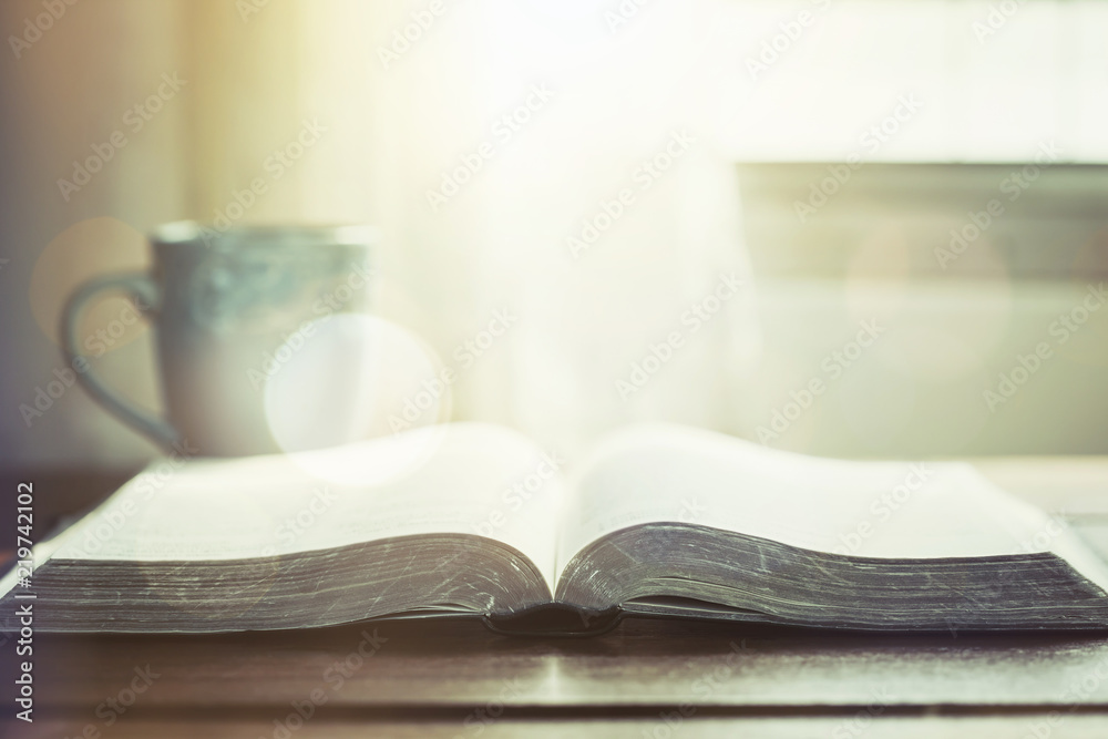 open bible book with a cup of coffee against window light in the morning, christian devotional open bible book with a cup of coffee against window light in the morning, christian devotional