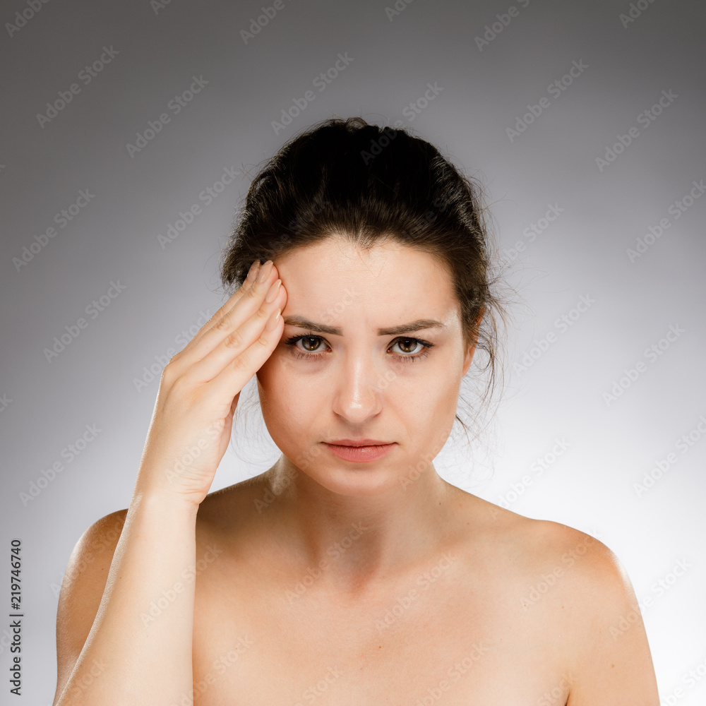 Woman massaging head pain on gray background Woman massaging head pain on gray background