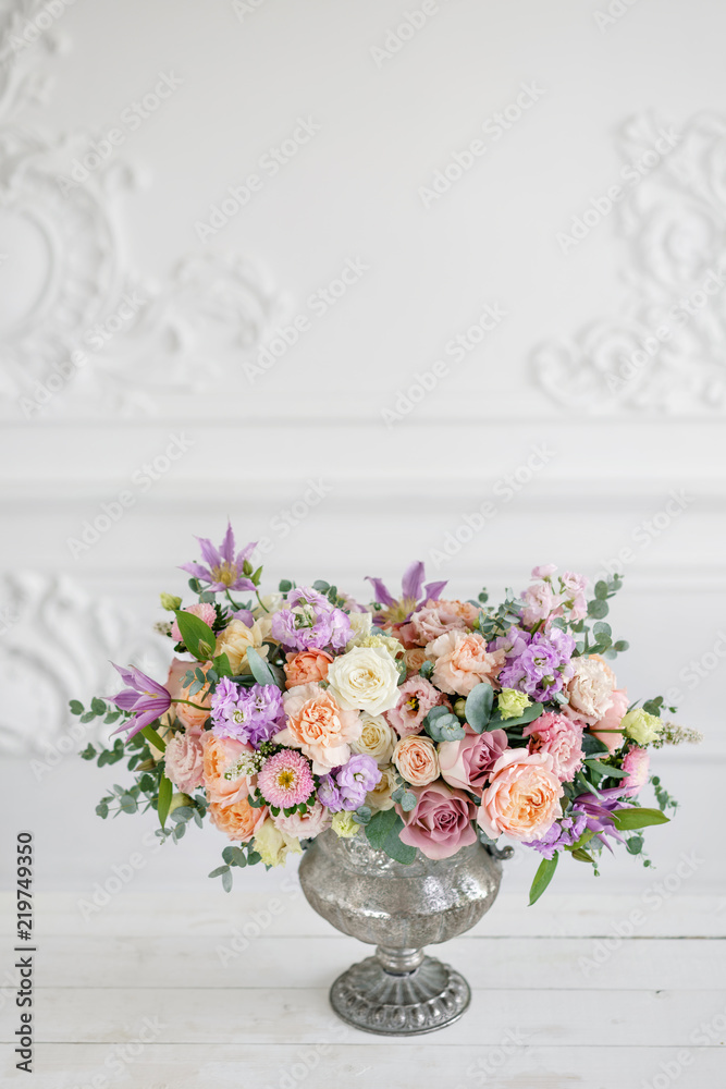 Gorgeous bouquet of different flowers. floral arrangement in vintage metal vase. table setting. lilac and peach color Gorgeous bouquet of different flowers. floral arrangement in vintage metal vase. table setting. lilac and peach color
