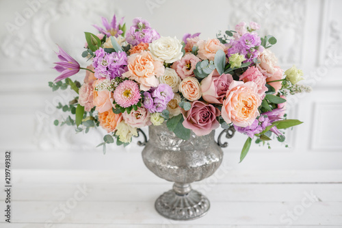Fototapeta Naklejka Na Ścianę i Meble -  Gorgeous bouquet of different flowers. floral arrangement in vintage metal vase. table setting. lilac and peach color