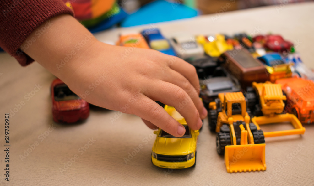 Naklejka premium Set of toy cars and the hand of a little boy.