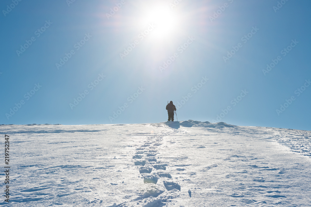 A man on the top of winter mountain with snow