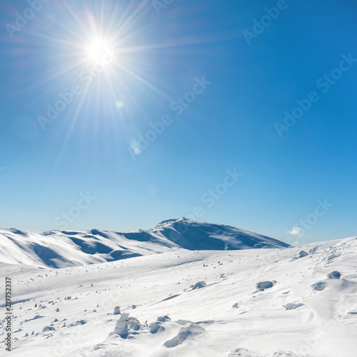 White winter mountains with snow and bright shining sun and sunrays © Pavlo Vakhrushev