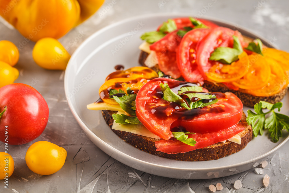 Sandwiches with tomatoes and cheese on gray plate, top view. Sandwiches with tomatoes and cheese on gray plate, top view.