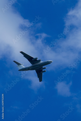 Blue sky with clouds and flying airplane