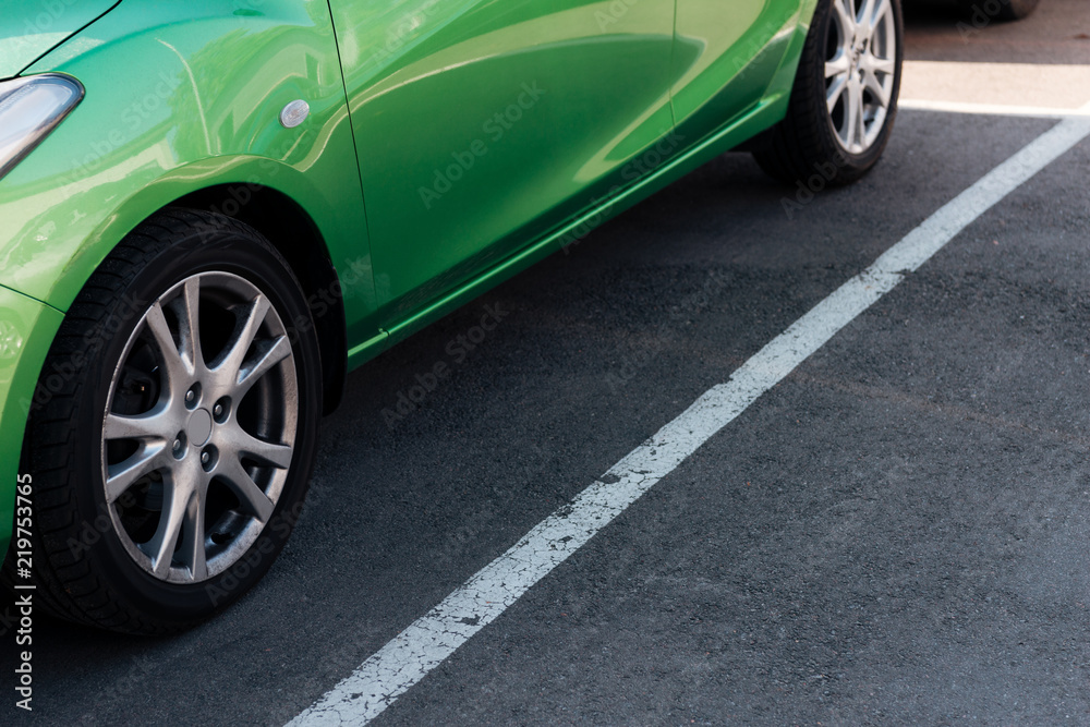 detail of green shiny car on parking lot
