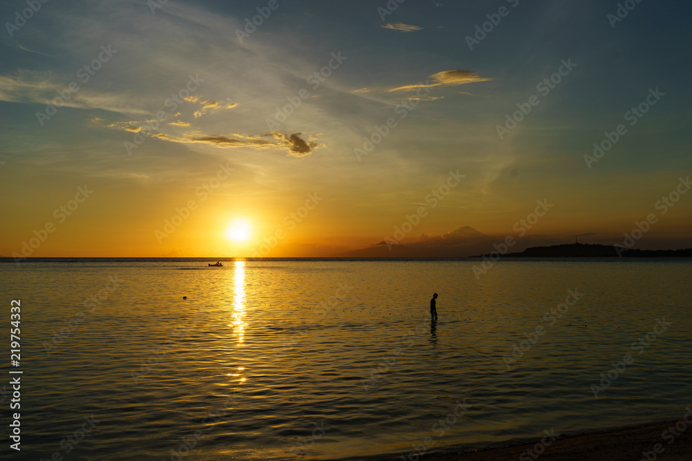 Fisherman in shallow water off shore Gili Air at sunset