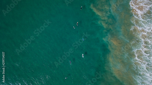 Surfers on beautiful day enyouing the waves in Australia, photographed from above using a drone.