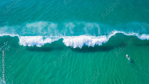 Surfers on beautiful day enyouing the waves in Australia, photographed from above using a drone. photo