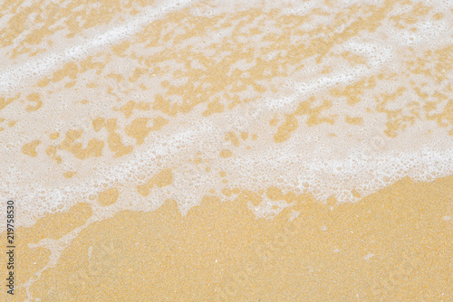 Soft wave foam on sandy beach