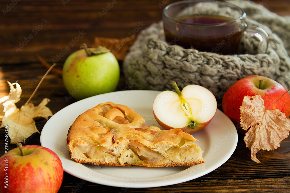 piec of an apple pie on a white plate on a wooden table