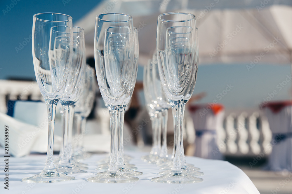 many empty wineglasses in rows at white table. welcome drink. catering many empty wineglasses in rows at white table. welcome drink. catering