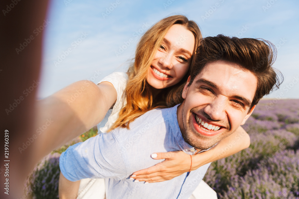 Happy young couple taking a selfie at the lavender field Happy young couple taking a selfie at the lavender field