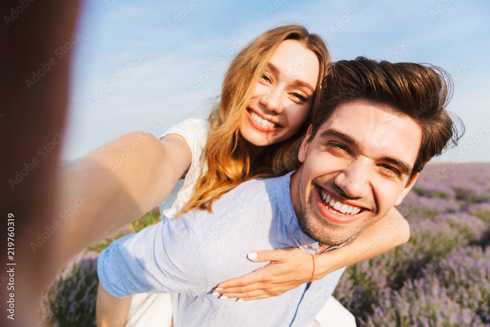 Happy young couple taking a selfie at the lavender field