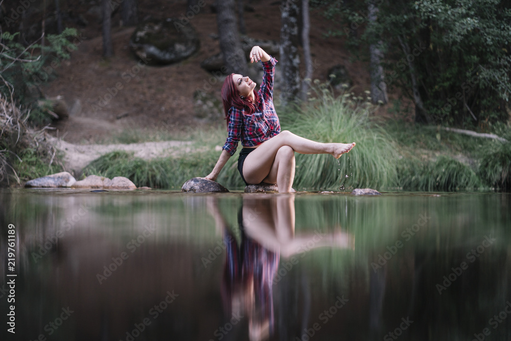 Pretty red haired girl rests by the river. Pretty red haired girl rests by the river.