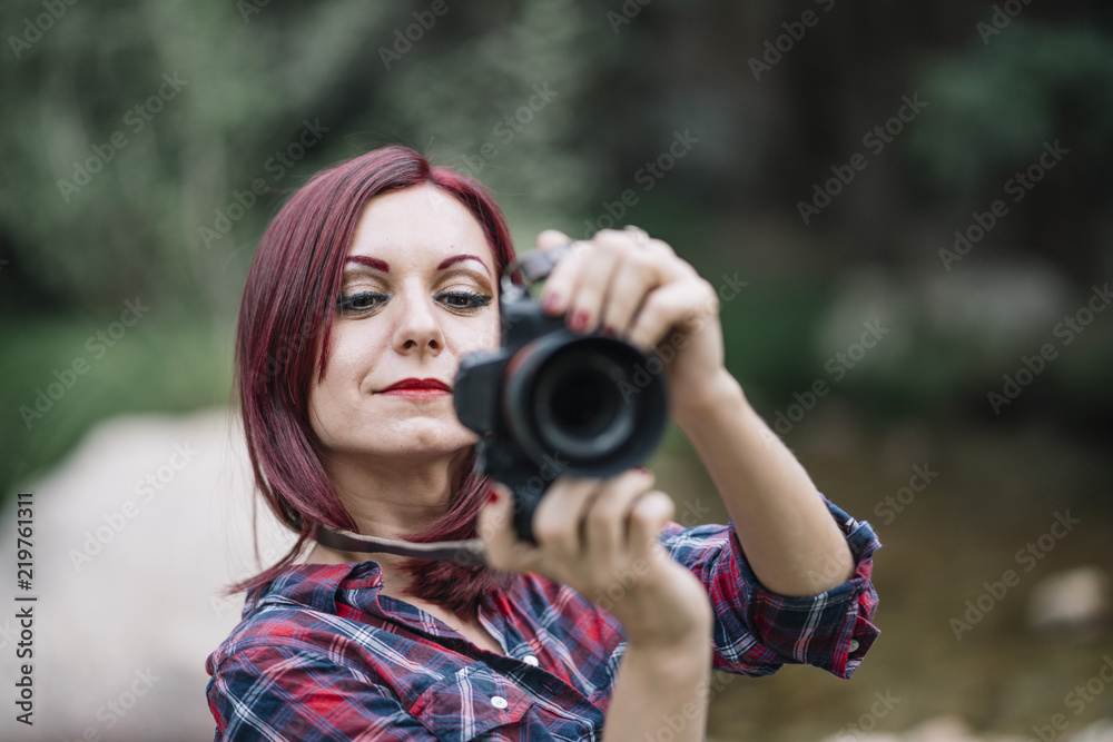 Pretty red haired girl takes pictures with camera. Pretty red haired girl takes pictures with camera.