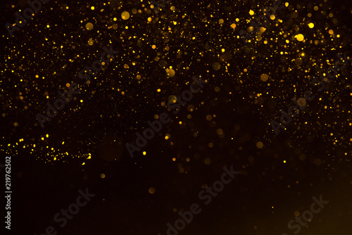 Glitter gold sparkling star dust falling shiny abstract bokeh background