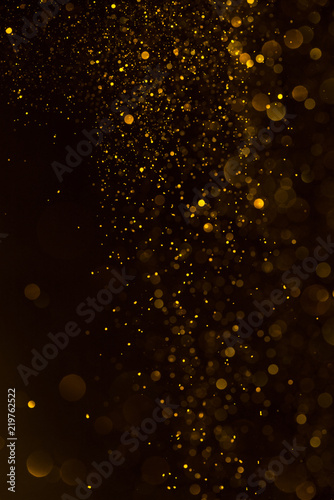 Glitter golden sparkling dust falling shiny abstract bokeh background
