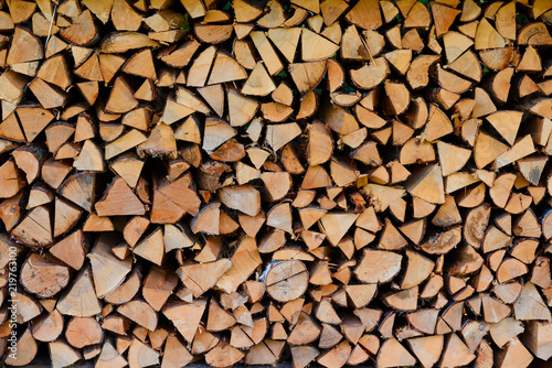 Firewood pile stacked chopped wood trunks for winter heating fireplace