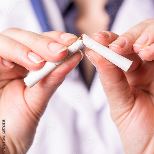 Cigarette addiction. Girl brakes cigarette. Shallow depth of field.