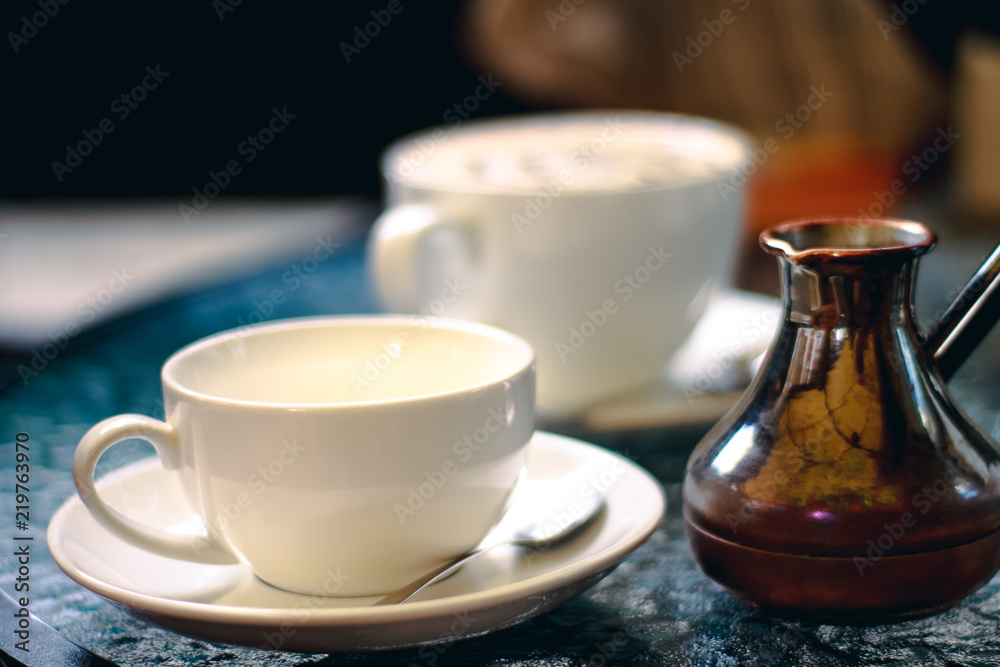 Cup of coffee with turk on the table in cafe or coffee shop. Retro vintage effect picture. Cup of coffee with turk on the table in cafe or coffee shop. Retro vintage effect picture.