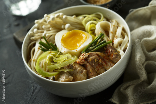 Asian style soup with noodles, egg, meat and mushrooms